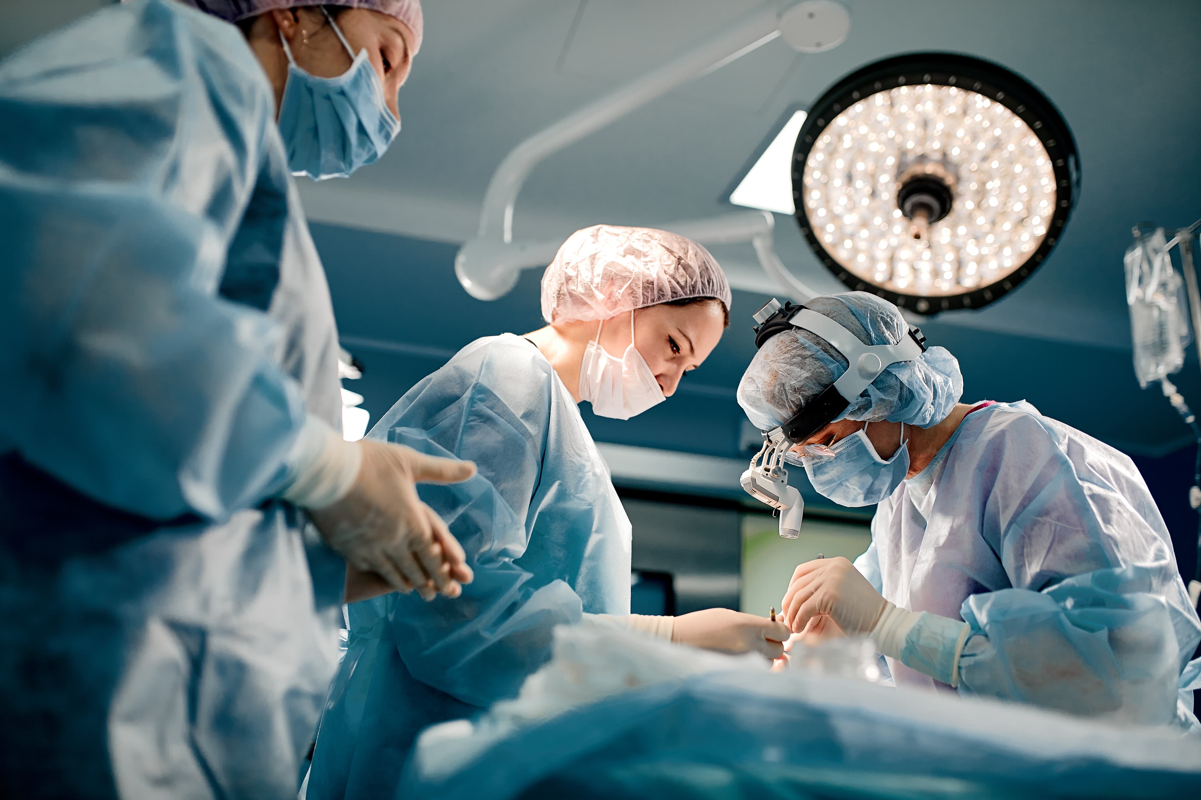 a group of doctors surrounding an operating room table